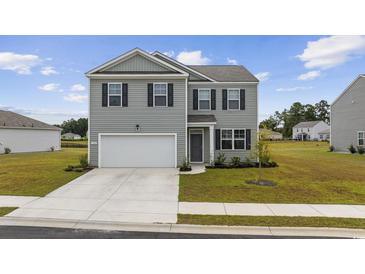 Two-story home featuring gray siding, a two-car garage, and a well-manicured front lawn at 128 Caveson Way, Conway, SC 29526