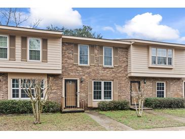 Traditional brick townhome featuring shuttered windows and manicured landscaping on a sunny day at 1409 Highway 15 # 4, Myrtle Beach, SC 29577