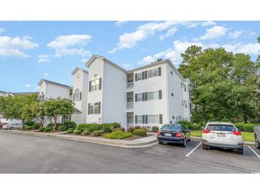 Condo building with white siding, black shutters, landscaping, and parking at 1529 Lanterns Rest Dr. # 201, Myrtle Beach, SC 29579