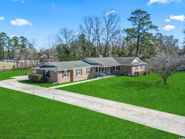 Stunning brick home with large front yard, long driveway, and well-maintained landscaping at 1586 Bridgebrook Ln., Conway, SC 29527