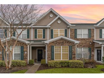 Attractive townhome featuring mixed brick and siding exterior and manicured landscaping at 159 Chenoa Dr. # E, Murrells Inlet, SC 29576