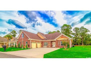 Charming brick home features an attached two car garage, well-manicured lawn, and traditional architectural details at 1796 Fairwinds Dr., Longs, SC 29568