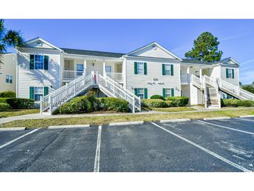 Beautiful condo featuring classic white siding, green shutters and access stairs at 4935 Crab Pond Ct. # 203, Myrtle Beach, SC 29579