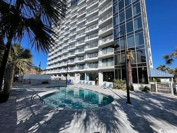 Resort pool with sun loungers and towering condominium in the background at 5511 N Ocean Blvd. # 1006, Myrtle Beach, SC 29577