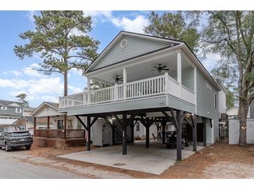 Charming coastal home featuring covered parking, large porch with fans, and light blue siding at 6001-1723 South Kings Hwy., Myrtle Beach, SC 29575