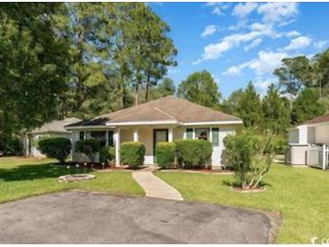 Charming single-story home featuring a well-maintained lawn, mature trees, and welcoming curb appeal at 6512 Laguna Point, Myrtle Beach, SC 29588