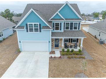 Charming two-story home with blue accents, a two-car garage, and a welcoming front porch at 860 Saluda River Rd., Myrtle Beach, SC 29588