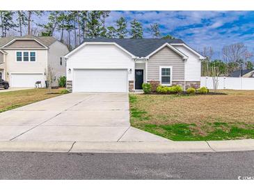 Charming one-story home featuring a two-car garage, white siding, a well-maintained yard, and a concrete driveway at 92 Costa Ct., Pawleys Island, SC 29585