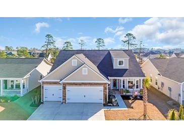 Beautiful two-story home with attached two-car garage, brick accents, and a well-manicured lawn at 166 New Paradise Way, Myrtle Beach, SC 29588