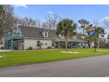 Charming one-story home with a well-manicured lawn, American and South Carolina state flags, and a cozy front porch at 390 Boundary Ave., Murrells Inlet, SC 29576