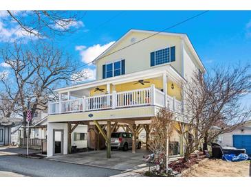 Charming yellow two-story home with spacious covered porch and ground-level parking on a sunny day at 6001- 5411 S Kings Highway, Myrtle Beach, SC 29575