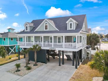 Charming raised beach house with a porch, columns, and well-maintained landscaping in a coastal setting at 119 Sunset Dr., Murrells Inlet, SC 29576