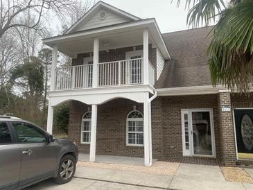 Charming two-story brick home featuring a cozy, covered second-story balcony and inviting front entrance at 1413 Cane St. # 1, North Myrtle Beach, SC 29582