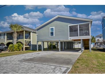 Coastal home on stilts featuring a paved driveway and screened-in porch for outdoor relaxation at 308 24Th Ave. N, North Myrtle Beach, SC 29582