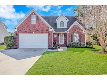 Charming brick home featuring a well-manicured lawn, attached two-car garage, and classic architectural details at 359 Rose Ave., Georgetown, SC 29440