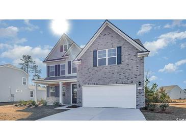 Charming two-story home with gray brick, a two-car garage, and well-maintained landscaping at 419 Clear Lake Dr., Conway, SC 29526