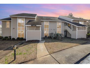 Charming condo with tan siding, complemented by manicured landscaping and inviting walkways at 4497 Little River Inn Ln. # 1507, Little River, SC 29566