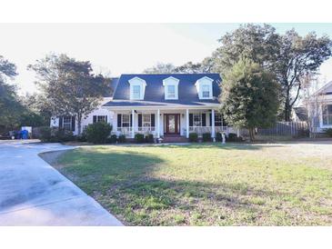 Charming home with a well-manicured front yard and a welcoming covered front porch at 823 Mount Gilead Place Dr., Murrells Inlet, SC 29576