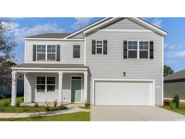 Charming two-story home showcasing a light gray exterior, black shutters, and a convenient attached two-car garage at 128 Shucking St., Myrtle Beach, SC 29588