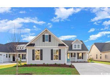 Charming single-Gathering home with light gray siding, black shutters, and a well-manicured lawn under a sunny blue sky at 385 Starlit Way, Myrtle Beach, SC 29579