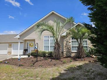 Charming home with a manicured lawn, stone accents, and delightful curb appeal with palm trees at 4239 Rivergate Ln., Little River, SC 29566