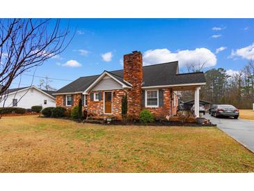 Charming brick home with a well-maintained lawn, inviting curb appeal, and covered parking space at 4908 Main St., Loris, SC 29569