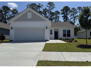 Charming single-story home with a well-maintained lawn, attached garage, and inviting entryway at 8643 Farrier Dr., Myrtle Beach, SC 29588