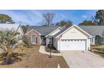 Charming single-Gathering home with well-maintained lawn, brick accents, and an attached two-car garage at 9430 Pinckney Ln., Murrells Inlet, SC 29576