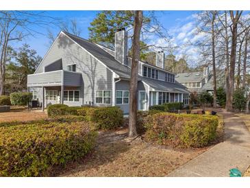 Charming gray two-story townhome exterior featuring mature landscaping, a private balcony, and driveway at 1205 Erin Way # 5C, Myrtle Beach, SC 29577