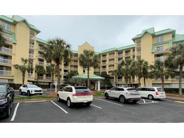 Beautiful condominium building with tropical landscaping and ample parking at 135 S Dunes Dr., Pawleys Island, SC 29585