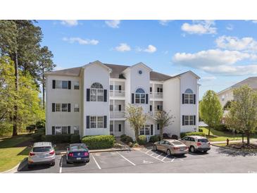 Three-story condo building features white siding, black shutters, and well-maintained landscaping at 1537 Lanterns Rest Rd. # 202, Myrtle Beach, SC 29579