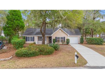 Charming single story home featuring mature trees, a well manicured front yard, and an attached garage at 177 Reef Run Rd., Pawleys Island, SC 29585