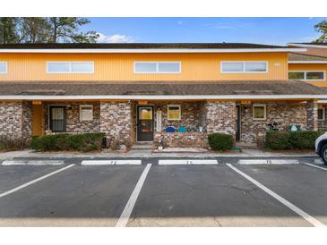 Charming two-story townhome with brick facade and covered porch, perfect for relaxing outdoors at 1851 Fairway Ridge # 7C, Surfside Beach, SC 29575