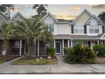 Charming townhomes with brick and siding exteriors, complemented by lush landscaping and mature palm trees at 3524 Crepe Myrtle Ct. # 3524, Myrtle Beach, SC 29577