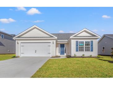 Charming one-story home with white siding, blue door, attached garage, and well-manicured lawn at 375 West Dogwood Rd., Loris, SC 29569