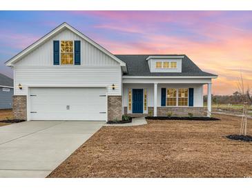 Charming new construction home features a two-car garage, blue shutters, and manicured front lawn at 379 West Dogwood Rd., Loris, SC 29569