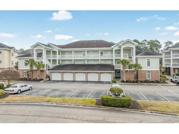 Attractive condo building with multi-car garages, palm trees, and ample parking at 4870 Dahlia Ct. # 304, Myrtle Beach, SC 29577