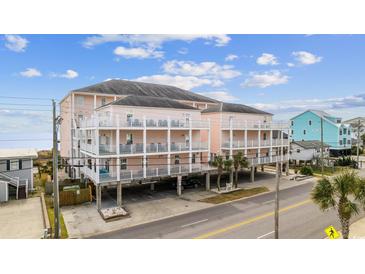 Coastal condo building featuring multiple balconies with white railings and covered parking at 817 S Ocean Blvd. # 105, North Myrtle Beach, SC 29582