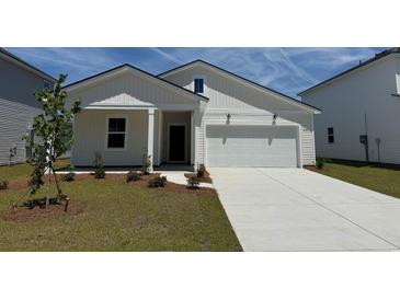Charming exterior of a bright, white, two-story home with a well-manicured lawn and a two-car garage at 1022 Laconic Dr., Myrtle Beach, SC 29588