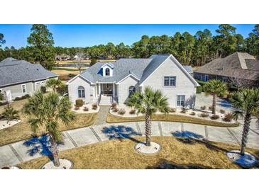 Stunning home with a well-manicured lawn, circular driveway, and lush palm trees at 3100 Lahinch Dr., Myrtle Beach, SC 29579