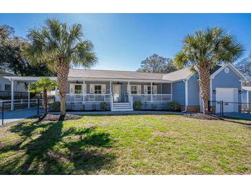 Charming single-story home featuring a spacious front porch and beautifully landscaped front yard with palm trees at 321 Jay St., Murrells Inlet, SC 29576