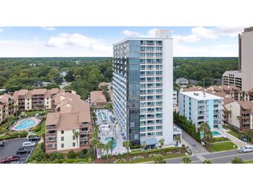 Stunning exterior view of condo building with pools, lush greenery, and beautiful landscaping at 5511 N Ocean Blvd. # 202, Myrtle Beach, SC 29577