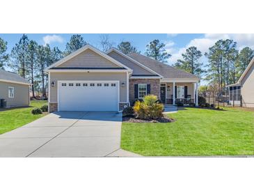 Charming single-Gathering home featuring a two-car garage, stone accents, and well-manicured lawn at 556 Timber Creek Dr., Loris, SC 29569