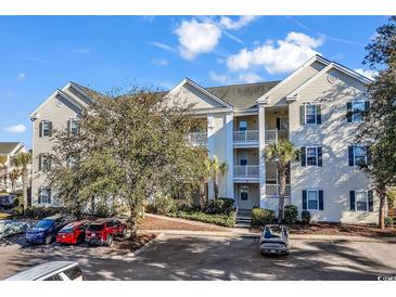Inviting condo complex featuring multiple levels, bright facades, balconies, manicured landscaping, and ample parking at 601 Hillside Dr. N # 3031, North Myrtle Beach, SC 29582