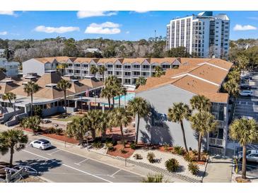 Beautiful resort featuring palm trees, an outdoor pool, and well-manicured landscaping at 6803 Ocean Blvd. N # 109, Myrtle Beach, SC 29572