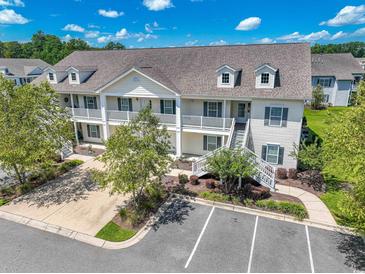 Charming two-story condo with white balconies and a well-maintained landscaped yard at 828 Sail Ln. # 203, Murrells Inlet, SC 29576