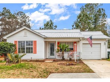 Charming single story home featuring tidy landscaping, an American flag, and a metal roof at 9514 Leeds Circle, Myrtle Beach, SC 29588