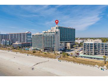 Stunning aerial view of a beachfront resort with a red pin, highlighting its prime location by the sandy beach at 205 74Th Ave. N # 1508, Myrtle Beach, SC 29572