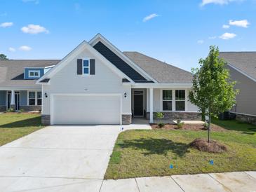 Charming single-Gathering home showcasing a well-manicured lawn, attached garage, and stone-accented facade at 2443 Campton Loop, Conway, SC 29527