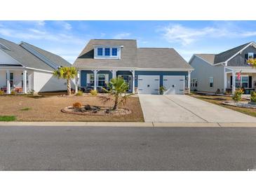 Charming blue home with a two-car garage and a manicured front yard at 533 Canborough Lane, Murrells Inlet, SC 29576
